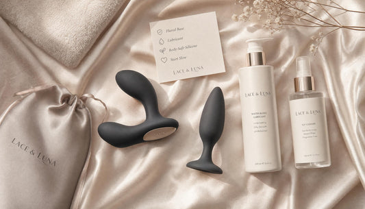 Luxury flat-lay of prostate massager, thick anal lubricant, toy cleaner, satin pouch, towel and safety note card.