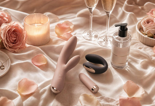 Luxury flat-lay of couples vibrators, water-based lubricant, satin pouch, candle and romantic date-night essentials.
