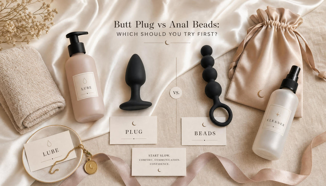 Luxury flat-lay comparing beginner butt plug and anal beads with thick anal lubricant, toy cleaner, satin pouch and towel.