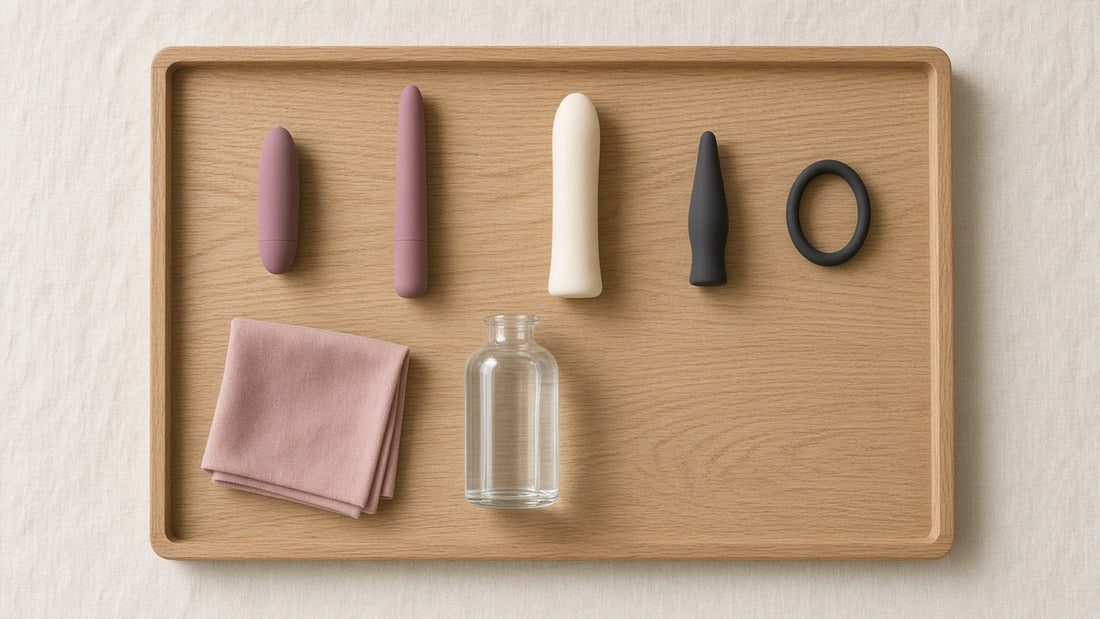 A bullet vibrator, wand, dildo, anal plug and cock ring laid out on an oak tray with lubricant, illustrating the main types of sex toys